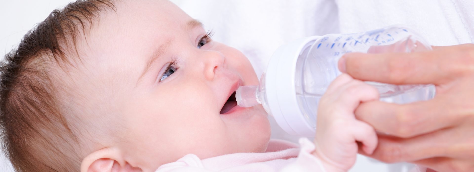 Portrait of beautiful innocence little baby drinking milk from plastic bottle