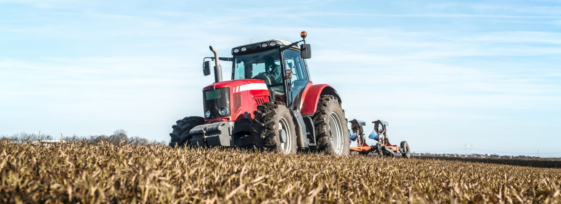 Tractor agricultural machine cultivating field.